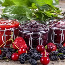 strawberry, cherry and mulberry jam on a rustic table
